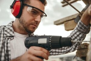 Builder working with drill on construction site