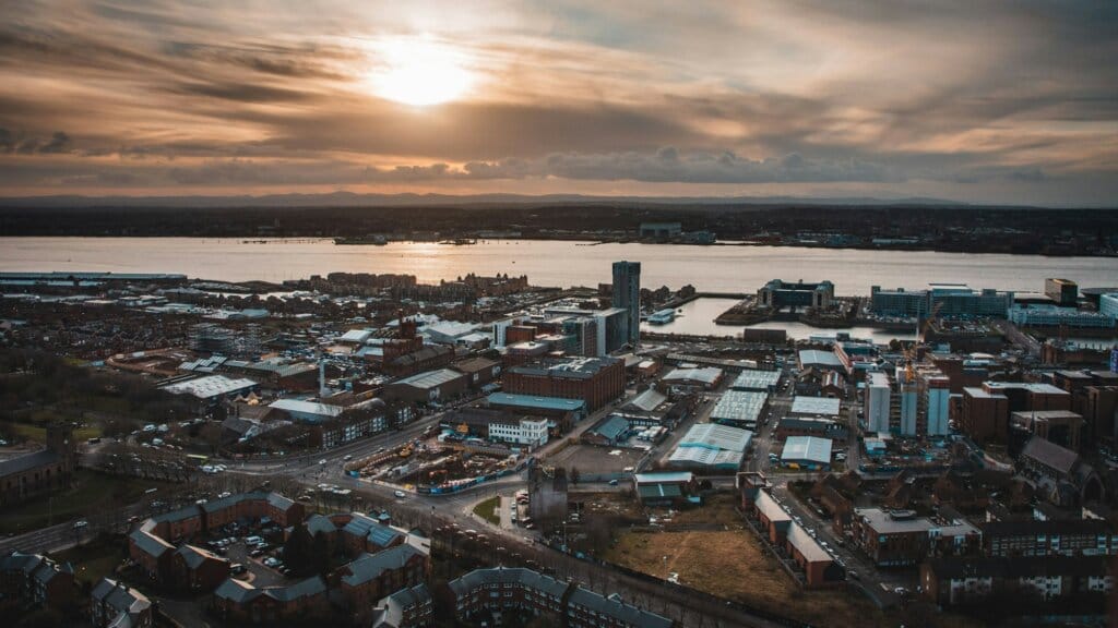 High angle shot of city buildings with the sea in the background in Liverpool, United Kingdom