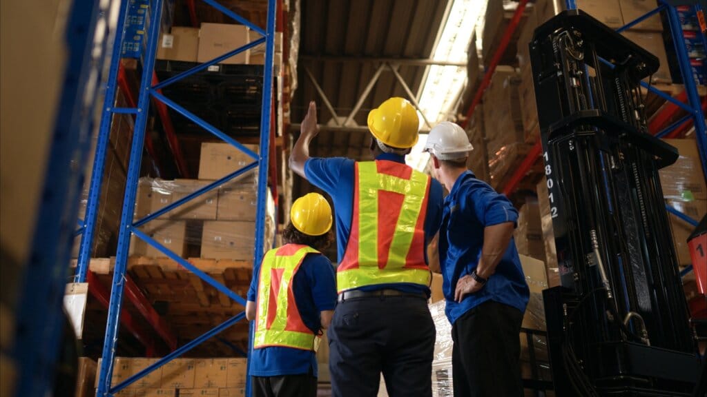 A bunch of warehouse workers are reviewing the list of items based on the documentation