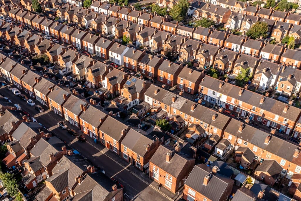 Aerial view above rows of back to back terraced houses on a large council estate